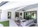 Stylish patio with modern furniture, ceiling fan, and views of the beautifully landscaped backyard and pool at 7108 Pelican Island Dr, Tampa, FL 33634