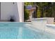 Close-up of the inviting pool, featuring a modern waterfall feature and meticulous tile work at 7108 Pelican Island Dr, Tampa, FL 33634
