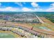 Stunning aerial view of a neighborhood with houses, ponds, commercial spaces, and a clear blue sky at 7929 Sail Clover Ln, Zephyrhills, FL 33540