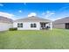 Large backyard with a covered patio that has comfortable seating and a grill at 7929 Sail Clover Ln, Zephyrhills, FL 33540