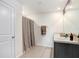 Well-lit bathroom features a double sink vanity, neutral tile, and shower with tan accents at 7929 Sail Clover Ln, Zephyrhills, FL 33540