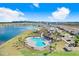 Community pool and lake with surrounding residences, lush landscaping, and a clubhouse, offering a serene retreat at 7929 Sail Clover Ln, Zephyrhills, FL 33540
