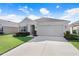 Charming single-story home with manicured landscaping, a two-car garage, and a well-maintained lawn at 7929 Sail Clover Ln, Zephyrhills, FL 33540