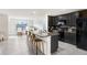 A modern kitchen boasts black cabinets, stainless steel appliances, and a granite countertop island with barstool seating at 7929 Sail Clover Ln, Zephyrhills, FL 33540