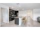A contemporary kitchen features an island with seating, stainless steel appliances, and modern cabinetry with ample storage at 7929 Sail Clover Ln, Zephyrhills, FL 33540