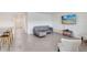 Open-concept living room with tile floors, a modern couch, and easy access to the kitchen and entryway at 7929 Sail Clover Ln, Zephyrhills, FL 33540