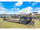 Community playground with play structures, a covered seating area, and a secure fenced perimeter at 7929 Sail Clover Ln, Zephyrhills, FL 33540