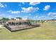 Community playground featuring play structures, swings, and a covered seating area, set on a well-maintained lawn at 7929 Sail Clover Ln, Zephyrhills, FL 33540