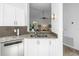 Granite countertops and stainless steel dishwasher in the kitchen with white cabinets at 826 Glades Ne Ct, St Petersburg, FL 33702