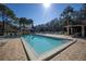 Community pool area with brick pavers, umbrellas, lounge chairs, and lush landscaping at 826 Glades Ne Ct, St Petersburg, FL 33702
