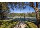 View of a tennis court, enclosed by a fence, with green grass and blue sky at 826 Glades Ne Ct, St Petersburg, FL 33702