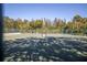 A well-maintained tennis court surrounded by green trees and a secure fence at 826 Glades Ne Ct, St Petersburg, FL 33702