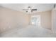 Spacious bedroom with a ceiling fan, neutral walls, carpet and a slider to the sunroom at 832 Fox Hills Dr, Sun City Center, FL 33573
