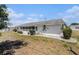 Back exterior view of a single story home with a screened porch, well-manicured landscaping, and central air conditioning at 832 Fox Hills Dr, Sun City Center, FL 33573