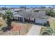 Charming single-story home with brick accents, complemented by a well-manicured lawn, mature palms, and a spacious driveway at 832 Fox Hills Dr, Sun City Center, FL 33573