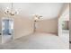 Open concept living room featuring a vintage chandelier, ceiling fan, and entry to the kitchen at 832 Fox Hills Dr, Sun City Center, FL 33573
