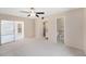Spacious main bedroom featuring a ceiling fan and doors to the bathroom and sunroom at 832 Fox Hills Dr, Sun City Center, FL 33573