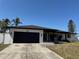 Charming single-story home featuring a modern black garage door and a well-manicured lawn at 926 Eagle Ln, Apollo Beach, FL 33572