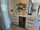 Kitchen features a wine fridge, white cabinets, marble countertops, and floating shelves with decorative accents at 926 Eagle Ln, Apollo Beach, FL 33572