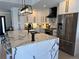 Modern kitchen features white cabinets, stainless steel appliances, and a large island with elegant marble countertops at 926 Eagle Ln, Apollo Beach, FL 33572