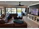 Cozy living room with a leather sectional and sliding glass doors leading to the pool area at 926 Eagle Ln, Apollo Beach, FL 33572