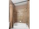 Full bath featuring a tiled tub/shower combination with tan tile surround and decorative accents at 10511 Mistflower Ln, Tampa, FL 33647