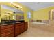 Bathroom featuring a double vanity, a soaking tub, and a separate shower at 10511 Mistflower Ln, Tampa, FL 33647