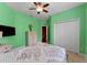Bedroom with green walls, a ceiling fan, carpeted floors, and a closet at 10511 Mistflower Ln, Tampa, FL 33647