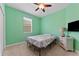Bedroom with green walls, a ceiling fan, carpeted floors, and a light-colored dresser with drawers at 10511 Mistflower Ln, Tampa, FL 33647