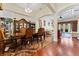 Elegant dining room with hardwood floors, a large cabinet, and an arched entrance to the adjacent living area at 10511 Mistflower Ln, Tampa, FL 33647
