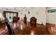 Elegant dining room with hardwood floors, a large table, and an arched entrance to the adjacent living area at 10511 Mistflower Ln, Tampa, FL 33647