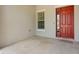 Welcoming front entrance with a decorative red door, tiled patio, and a glimpse of home's exterior at 10511 Mistflower Ln, Tampa, FL 33647