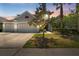 Charming home featuring a three-car garage, manicured landscaping, and a picturesque setting at sunset at 10511 Mistflower Ln, Tampa, FL 33647