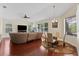 Open-concept living room featuring a dining area, hardwood floors, a ceiling fan, and natural light at 10511 Mistflower Ln, Tampa, FL 33647
