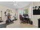Sunlit office features a dark desk, multiple monitors, and an exercise area with weights at 10511 Mistflower Ln, Tampa, FL 33647