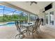 Covered outdoor patio with a ceiling fan overlooking a sparkling pool and lush greenery, perfect for relaxing and dining at 10511 Mistflower Ln, Tampa, FL 33647