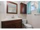This bathroom features a vanity, mirror, medicine cabinet, toilet, and tile walls at 1099 7Th Ne Ave, Largo, FL 33770