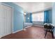Light-filled bedroom highlighting bright blue walls, hardwood floors, and abundant natural light from the windows at 1099 7Th Ne Ave, Largo, FL 33770