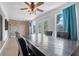 Dining room with a decorative ceiling fan, brick wall accent, and natural light from the windows at 1099 7Th Ne Ave, Largo, FL 33770