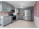 Modern kitchen featuring stainless steel appliances, gray cabinets, and a stylish backsplash at 1099 7Th Ne Ave, Largo, FL 33770