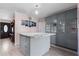 Well-lit kitchen featuring grey cabinets, an island with granite countertop, and modern appliances at 1099 7Th Ne Ave, Largo, FL 33770
