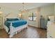Spacious bedroom with a decorative chandelier, light green walls and hardwood floors at 1220 Florablu Dr, Seffner, FL 33584