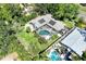 Aerial view of a home with a screened pool, lush greenery, and ample yard space at 1220 Pinellas Point S Dr, St Petersburg, FL 33705