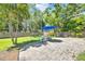 Relaxing backyard featuring a paver patio with an umbrella and a table with chairs, ideal for entertaining at 1220 Pinellas Point S Dr, St Petersburg, FL 33705