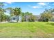 Expansive backyard featuring lush lawn, landscaping, patio, and screened-in pool at 1220 Pinellas Point S Dr, St Petersburg, FL 33705