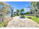 Inviting backyard with a paver patio, chairs, and a lush lawn, perfect for outdoor relaxation at 1220 Pinellas Point S Dr, St Petersburg, FL 33705