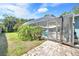 Backyard view of a screened-in pool, and lush greenery with fence and gate at 1220 Pinellas Point S Dr, St Petersburg, FL 33705
