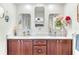 Elegant bathroom featuring double vanities, decorative mirrors, and quartz countertops at 1220 Pinellas Point S Dr, St Petersburg, FL 33705