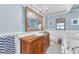 Charming bathroom with a wood vanity, elegant fixtures, chandelier, and tiled floors and backsplash at 1220 Pinellas Point S Dr, St Petersburg, FL 33705