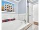Close-up of bathroom tub featuring elegant tiling, fixtures, and a bright window view of the outdoors at 1220 Pinellas Point S Dr, St Petersburg, FL 33705
